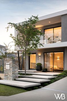 a modern house with stone steps leading to the front door