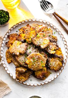 a white plate topped with potatoes covered in parmesan cheese next to other dishes