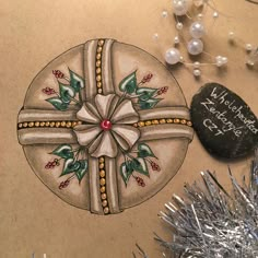 a christmas ornament with a cross on it next to a rock and tinsel