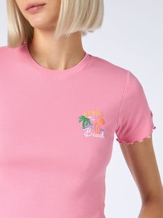 This crewneck tee is crafted from ribbed cotton and adorned with iconic and playful captions. The embroidered Saint Barth logo on the sleeve provides a textured and dimensional touch to this fashionable t-shirt. Woman ribbed cotton t-shirtSnug fitDesigned to hit at the waistPink ribbed cottonCrewneckShort sleevesAprès Beach embroideryRuffled hemsSaint Barth logo signature embroidered on the sleeveComposition: 100% cottonRegular fitModel is 176 cm and wears a size S. Trendy Summer T-shirt With Ribbed Neckline, Pink Ribbed Cotton T-shirt, Ribbed Cotton T-shirt For Summer, Pink Ribbed Crew Neck T-shirt, Fitted Summer Tops With Embroidered Graphics, Pink Summer Tops With Embroidered Graphics, Pink Embroidered Summer Top, Pink Embroidered Tops For Summer, Summer Tops With Ribbed Neckline