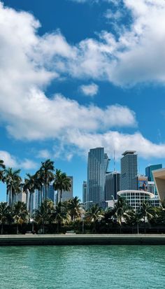 the city is surrounded by tall buildings and palm trees, as well as blue water