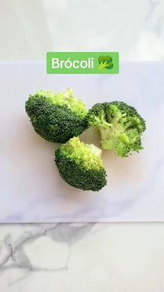 broccoli florets sitting on top of a white cutting board