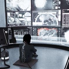 a little boy sitting in front of a computer screen with multiple monitors on it's sides