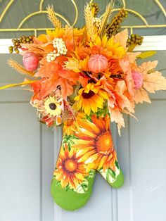 a green stocking with flowers in it hanging on a door