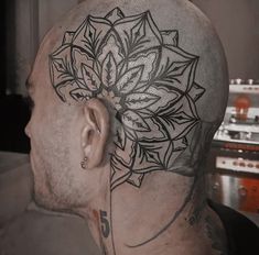 a man with a flower tattoo on his head