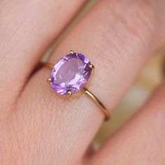 How can something so simple as an oval Amethyst solitaire ring, be so beautiful, you ask? The answer is in the gemstone itself. With a gorgeous vivid purple color, this ring just pops out on your finger and dazzles everyone. To turn it up a notch, add complimentary stacking rings, to create a one-of-a-kind ring set - something extra special for yourself or your loved one. Details: Center gemstone: Amethyst Stone Shape: Oval Measurements: approx. 9x7 mm Weight: approx 1.75 ct Band measurements: a Luxury Classic Solitaire Amethyst Ring, Luxury Classic Oval Amethyst Ring, Purple Oval Birthstone Ring, Oval Solitaire Amethyst Promise Ring, Oval Purple Solitaire Birthstone Ring, Oval Lavender Amethyst Ring For Gift, Lavender Oval Amethyst Ring For Gift, Purple Amethyst Solitaire Ring In Oval Shape, Purple Solitaire Amethyst Ring With Oval Shape