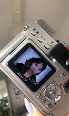 a person holding up a digital camera to take a picture with the image on it