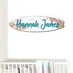 a sign that says hannah james on it in front of a crib and baby's bed