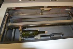 a bottle of wine is sitting in an oven with it's door open to reveal the inside