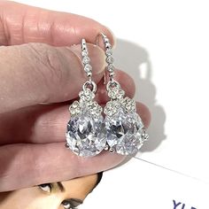 "A pair of classic teardrop cz drop bridal earrings made of sparkly clear pear shape cubic zirconia with cz studded caps bearing detailed flower clusters on white gold silver rhodium plated hooks. Earrings are about 1 1/2\" (4cm) long with hooks. View all earrings at https://etsy.me/1f8VFT4" Diamond White Drop Diamond Earrings For Wedding, Teardrop Cubic Zirconia Cluster Earrings For Party, Cubic Zirconia Bridal Earrings With Sparkling Stones, Diamond White Bridal Earrings With Sparkling Stones, White Teardrop Earrings With Prong Setting For Wedding, Crystal Drop Diamond Earrings For Wedding, Drop Chandelier Earrings With Prong Setting For Wedding, Sparkling Drop Bridal Earrings For Wedding, Silver Drop Diamond Earrings For Wedding