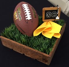 a football sitting on top of green grass next to a wooden box with a keychain