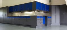 an empty garage with blue and grey cabinets