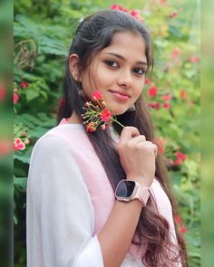 a girl with long hair holding a flower in her hand