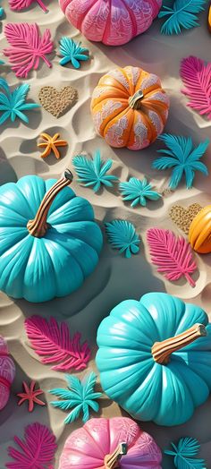 colorful pumpkins and other decorative objects are arranged on the sand in this artistic display