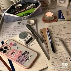 an assortment of personal items on a desk with notebooks, pens and pencils