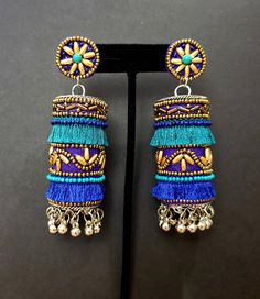 Fun and playful Afghani fringe earrings, with gold tone bead work. The perfect summer earring, colorful and carefree. Fabric backed ear stud ensures a comfortable fit. The main body is fabric wrapped around a metal cylinder. Beautiful vibrant colors. Little bells make a lovely sound when you move your head. Weight 21 gm. Find even more great earrings here: https://www.etsy.com/shop/boutiquebymaryam?section_id=22797814 Be sure to visit the rest of my shop here: https://www.etsy.com/shop/boutiqueb Traditional Beaded Fringe Earrings For Festival, Traditional Beaded Earrings With Fringe For Festivals, Blue Bohemian Jhumkas For Festive Occasions, Festive Bohemian Jhumkas, Blue Latkans Danglers For Party, Blue Danglers With Latkans For Party, Blue Party Danglers With Latkans, Bohemian Festive Jhumkas, Blue Festival Earrings With Latkans