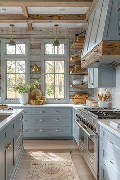 a kitchen with blue cabinets and white counter tops, wooden ceiling beams and open windows