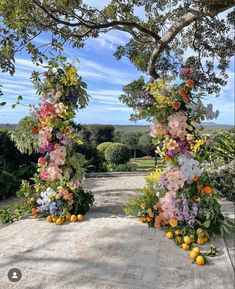 an archway decorated with flowers and oranges