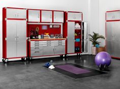 a garage with exercise equipment and yoga mat on the floor in front of red cabinets