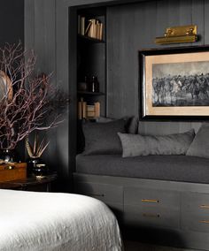 a bed sitting next to a book shelf filled with books