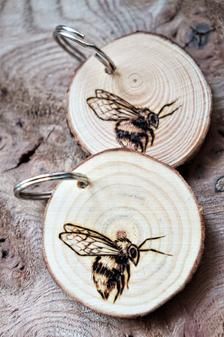 two wooden coasters with bees on them