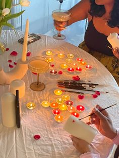 two women sitting at a round table with candles and wine glasses in front of them