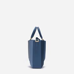 The new Sera Tall Tote is designed to carry your daily essentials, it can easily fit a large phone (like iPhone 15 Pro Max), mini wallet or cardholder, keys, lipstick, etc.Its exterior design is a surrealist dream, reminiscent of a maze-like structure protruding outwards, with sharp, clean lines, and a 3D façade. It has a suede drawstring top, securing your belongings on the go.Folding inwards like an accordion and then stretching outwards to store those last-minute belongings. The Sera Tall Tot Modern Blue Bags With Interior Card Slots, Modern Rectangular Bag With Cell Phone Pocket, Modern Rectangular Case Bag With Cell Phone Pocket, Modern Rectangular Case Bags With Cell Phone Pocket, Modern Blue Rectangular Case Bag, Modern Square Bag With Cell Phone Pocket, Modern Evening Bag With Card Slots, Modern Evening Bags With Card Slots, Chic Rectangular Case Bag With Card Slots