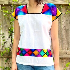 "Modern Geometric Huipil Blouse 100% Made by Ch'ol Artisans in Chiapas, Mexico. The bold geometric designs found in these huipil blouses are like no other! The front of the blouse includes a bold line of embroidery that accentuates all outfits. Mayan Ch'ol artisans from the northern highlands of Chiapas, Mexico, create these ravishing stylized huipil blouses. The intricate geometric design found in this blouse is representative of Ch'ol traditional garments, achieved by embroidering small square Cheap Geometric Embroidered Summer Tops, Bohemian Cotton Top With Geometric Pattern, White Blouse With Geometric Pattern For Spring, Fitted Short Sleeve Tops With Geometric Embroidery, Fitted White Tops With Geometric Pattern, White Geometric Pattern Blouse For Summer, White Blouse With Geometric Pattern For Summer, White Fitted Top With Geometric Embroidery, Fitted White Top With Geometric Embroidery