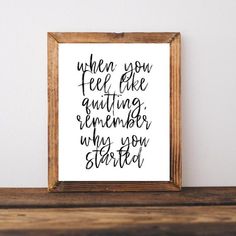 a wooden frame with a handwritten quote on it sitting on a shelf next to a white wall