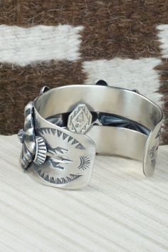 This sterling silver bracelet was made by Navajo silversmith Andrew Gordon. The inside is signed G and stamped sterling.Size: 5 3/8" (will fit up to a 6 3/8" wrist)Gap: 1 1/8"Width: 1 1/2"Free shipping on all orders! We ship with USPS and always include tracking. All orders ship within a day of payment.Returns are accepted up to 30 days after you receive your order. Just send us a message. Our shop offers cash back or store credit. The item must be returned in new condition. Southwestern Silver Cuff Bracelet, Silver Artisan Bracelet, Western Sterling Silver Cuff Bracelet With Concho, Artisan Sterling Silver Concho Cuff Bracelet, Western Silver Cuff Bracelet With Concho, Sterling Silver Southwestern Bracelet With Polished Finish, Artisan Silver Concho Cuff Bracelet, Unique Stamped Sterling Silver Collectible Bracelet, Western Silver Concho Cuff Bracelet