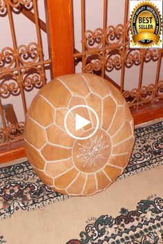 a large round stone sitting on top of a rug in front of a wooden door