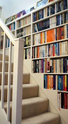 there is a stair case full of books on the wall