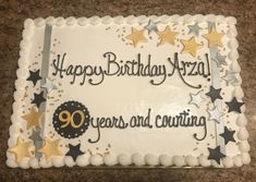 a birthday cake with stars and the words 90 years and counting on it is sitting on a table