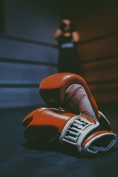 a pair of red boxing gloves laying on the ground