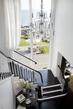 the stairs in this house have been decorated with chandelier and black railings