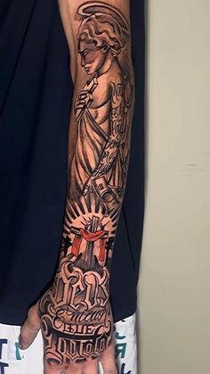 a man's arm with tattoos on it and his hand holding the statue of liberty