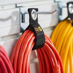 several different colored cords are hanging on the wall next to each other in front of wires