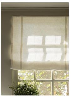 an open window with white curtains and a potted plant