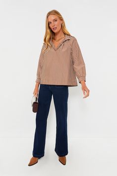 The Mocha Emy Top is exactly what we want in a blouse — effortless, elegant, and ultra-versatile. Made in a neutral colorway that pairs well with just about anything, this relaxed silhouette features a stand collar for an extra bit of elegance, as well as bracelet length raglan sleeves that allow you to accessorize and vertical stripes to elongate the body. Style it with trousers and slingback heels for an elevated office look, or go for denim and crisp white sneakers for weekend wear! Stand col Chic Brown Tops For Business Casual, Chic Brown Top For Business Casual, Chic Relaxed Fit Blouse With Split Neck, Chic Blouse With Split Neck And Relaxed Fit, Chic Split Neck Blouse With Relaxed Fit, Brown Collared Blouse With Relaxed Fit, Brown Relaxed Fit Collared Blouse, Classic Brown Blouse With Relaxed Fit, Brown Relaxed Fit Blouse For Fall