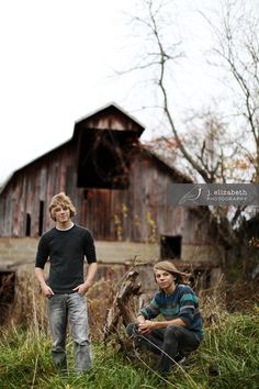 two people standing in front of a barn