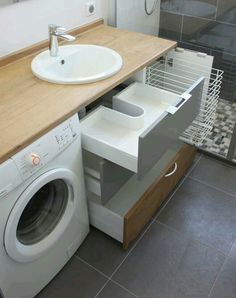 a washer and dryer in a bathroom with tile flooring on the walls