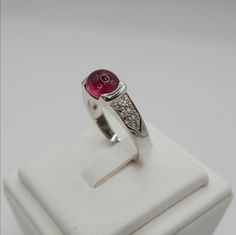 The Center Stone is a Beautiful Natural 2.5ct+ Pink Tourmaline Ring size: 6.5 US. It is resize-able. We'll resize it free of cost Handmade Ring ≫ Gemstones ◈ Gemstone: Natural Tourmaline ◈ Gemstone Carat: 2.5carat's+ ◈ Gemstone Cut: Oval Cabochon ◈ Gemstones Color: Pinkish Red ◈ Gemstones Clarity: Natural Inclusions ≫Diamonds ◈ Diamond Carats: 0.30 carats ◈ Diamond Cut: Round (14pcs) ◈ Diamond Type: 100% Natural earth mined Platinum Ruby Ring In Silver Color As Gift, Platinum Ruby Ring As A Gift, Platinum Ruby Ring With Diamond Accents As A Gift, Ruby Ring With Diamond Accents In Platinum, Platinum Ruby Ring With Diamond Accents For Gift, White Gold Platinum Ruby Ring As A Gift, Formal White Gold Ruby Ring With Pave Setting, Silver Platinum Ruby Ring Gift, Hallmarked Pink Ruby Rings