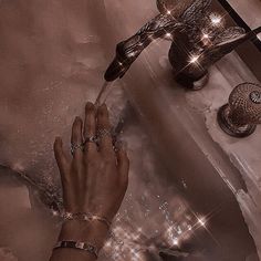 a person washing their hands in a bathtub with lights on the faucet