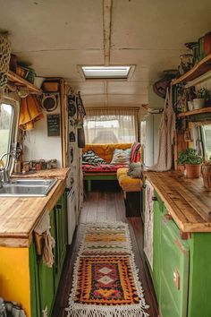 the interior of an rv with green cabinets and wood flooring is decorated in bohemian style