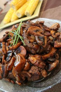 a plate full of mushrooms and corn on the cob