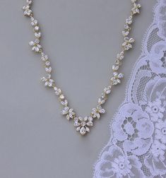 "Marquise cut crystals in a graceful leaf design create the most stunning bridal necklace, with gorgeous sparkle. We have designed this beautiful necklace to enhance your décolletage for an elegant and very sophisticated touch to your wedding day jewels. ❣ Highest-quality cubic zircons set in tarnish-resistant 18K gold plate. ❣ Cadmium and nickel-free. ❣ Also available with a crystal teardrop as seen in image 4. ❣ Length is 16.5\" with an optional 1.5\" extender. ❣ Shopping for your bridal party Dazzling Marquise Diamond Necklace For Wedding, Delicate Gold Diamond Necklace For Wedding, Gold Diamond Wedding Backdrop Necklace, Wedding Gold Diamond Backdrop Necklace, Gold Diamond Backdrop Necklace For Wedding, White Marquise Necklace For Wedding, Dazzling Marquise Wedding Necklace, Delicate Marquise Necklace For Wedding, Delicate Marquise Wedding Necklaces