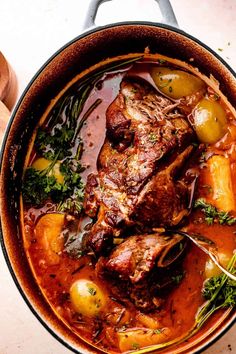 a pot filled with meat and vegetables on top of a table