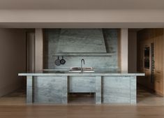 a modern kitchen with marble counter tops and stainless steel appliances on the wall, along with hardwood flooring