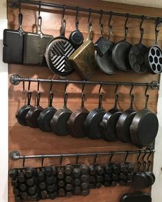 a wall mounted rack with pots and pans on it