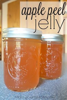 two jars filled with apple jelly sitting on top of a counter